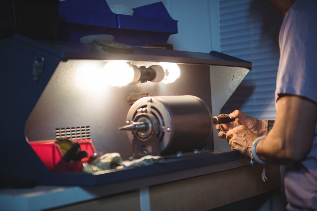Mid-section of craftswoman working on a machine in workshop